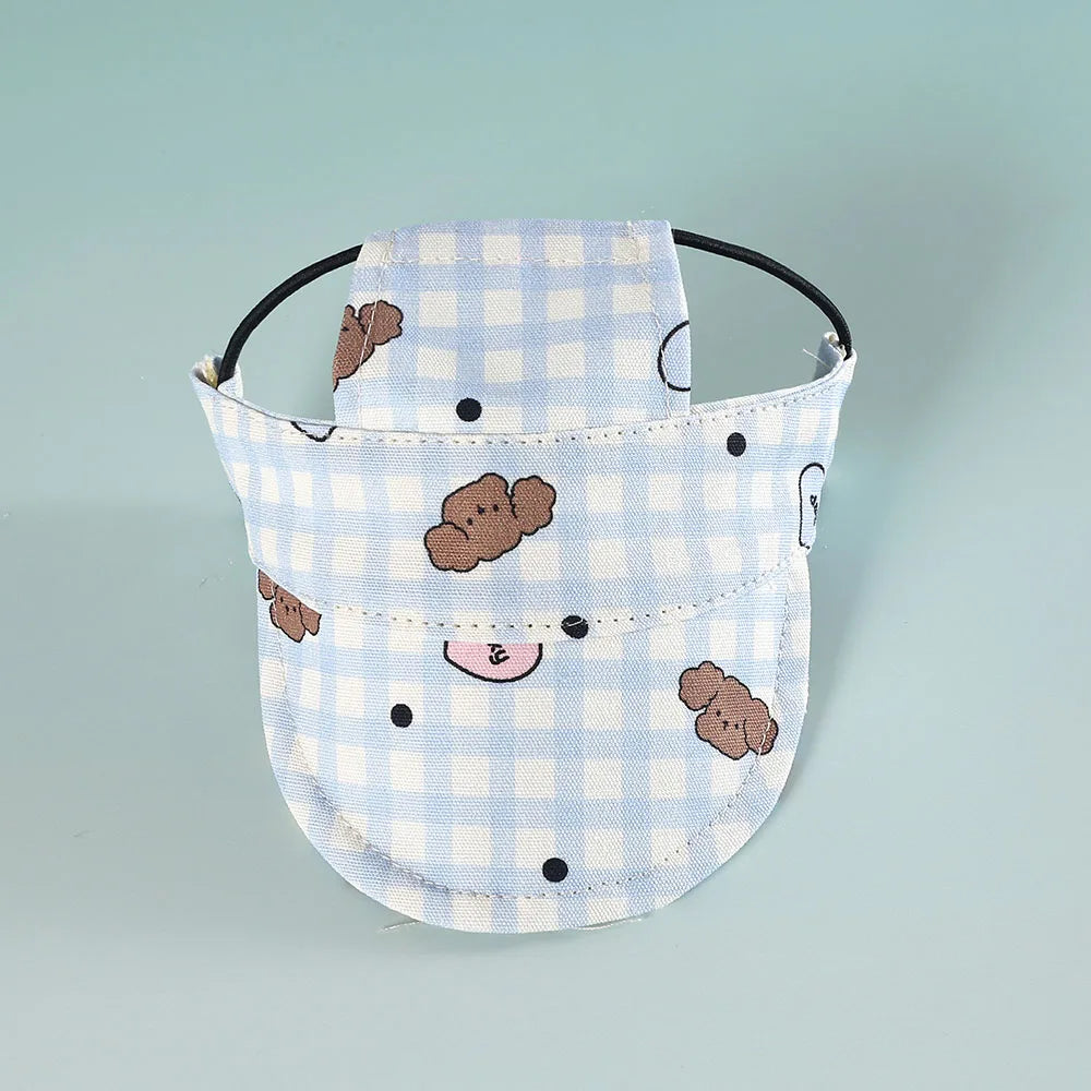 Baby dog hat with blue checkered pattern and bear designs on a light blue background