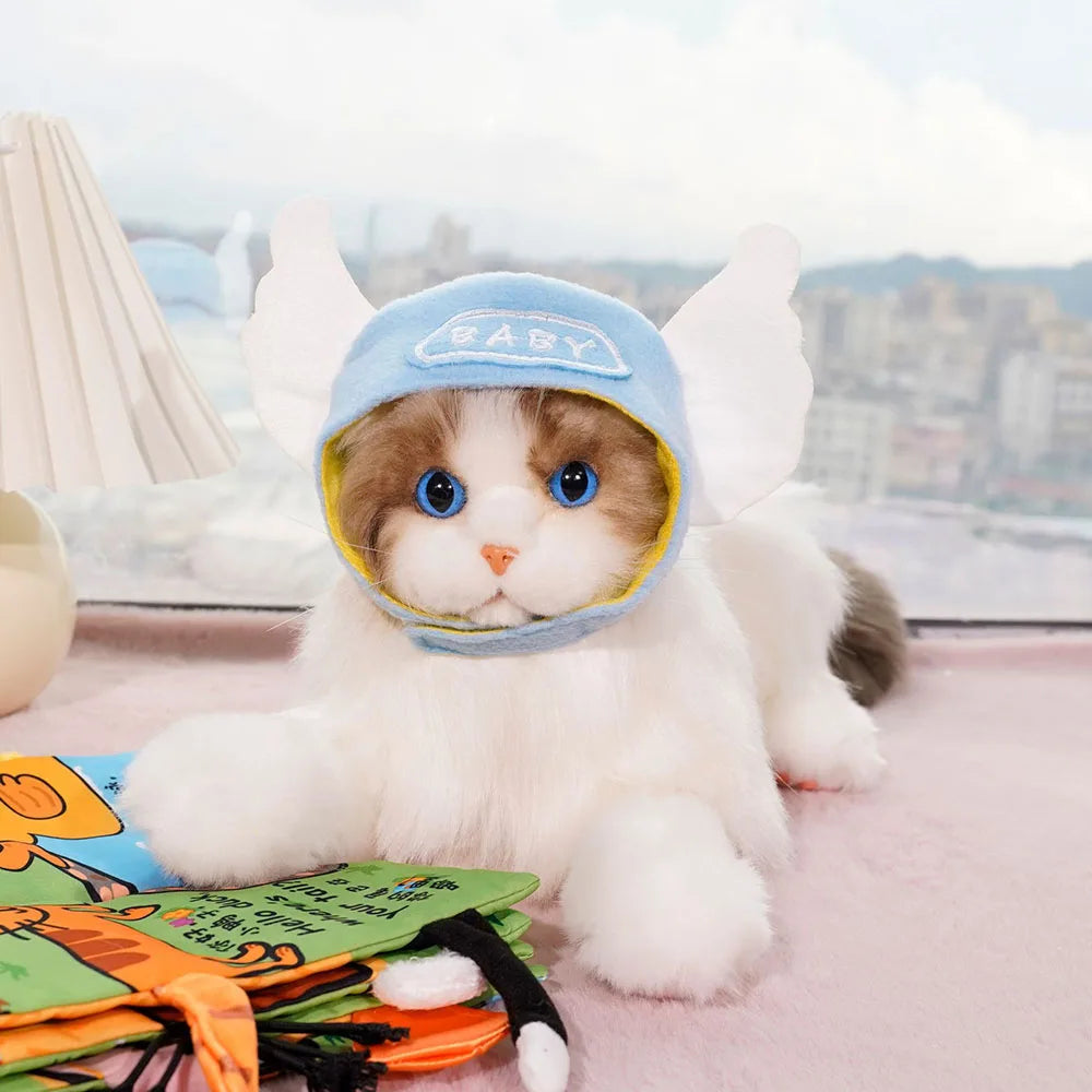 Cat wearing a blue hat with bunny ears on a pink surface
