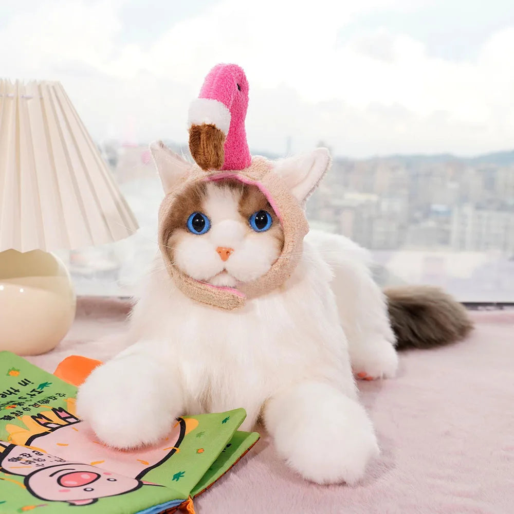 Cat wearing a unicorn hat on a pink blanket with a cityscape in the background