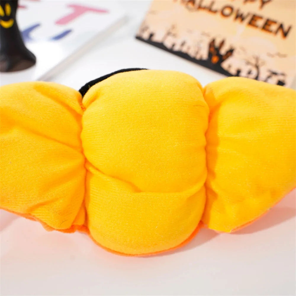 Close up of Halloween-themed pet hat with witch hat and pumpkin design on a white background