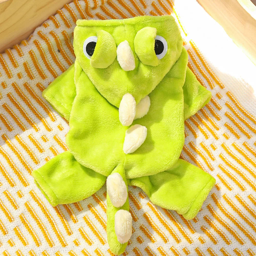 Green dinosaur-themed pet romper on a textured surface