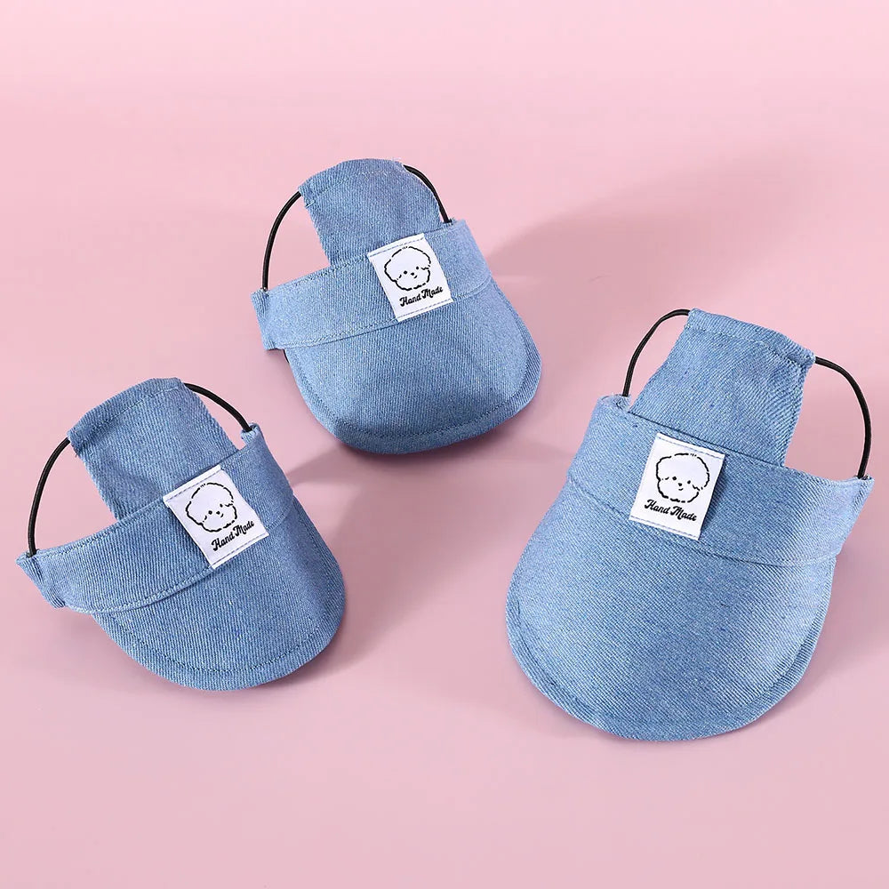 Three denim-colored pet brim hat with a brand label on a pink background