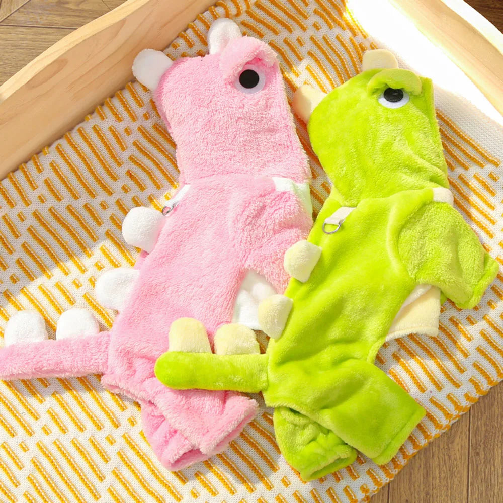Two pet outfit, one pink and one green, on a textured surface.