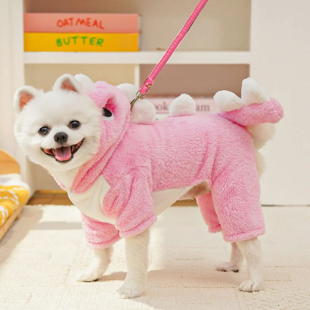 White dog wearing a pink dino outfit with a leash