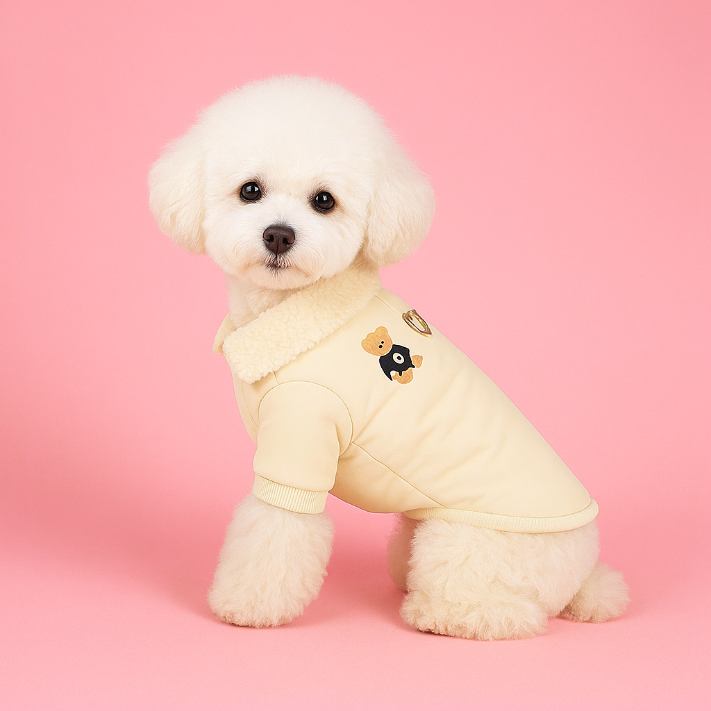 White dog wearing a yellow outfit with a bear design on a pink background
